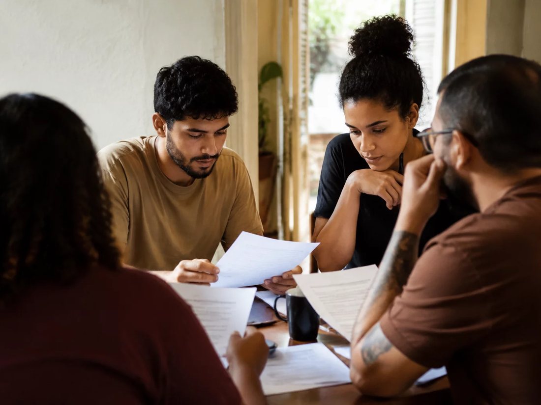 Equipe reunida numa sala clara enquanto uma pessoa explica sua proposta