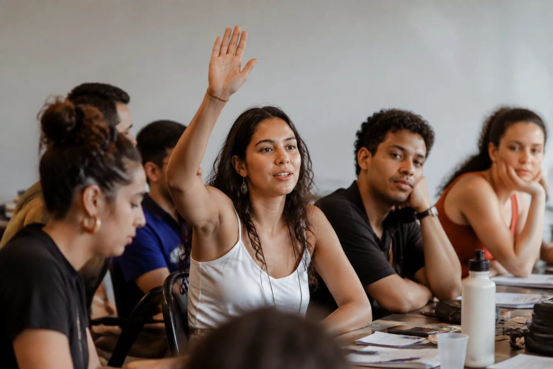 Dupla organizando o roteiro de um debate com cadernos e canetas marca-texto